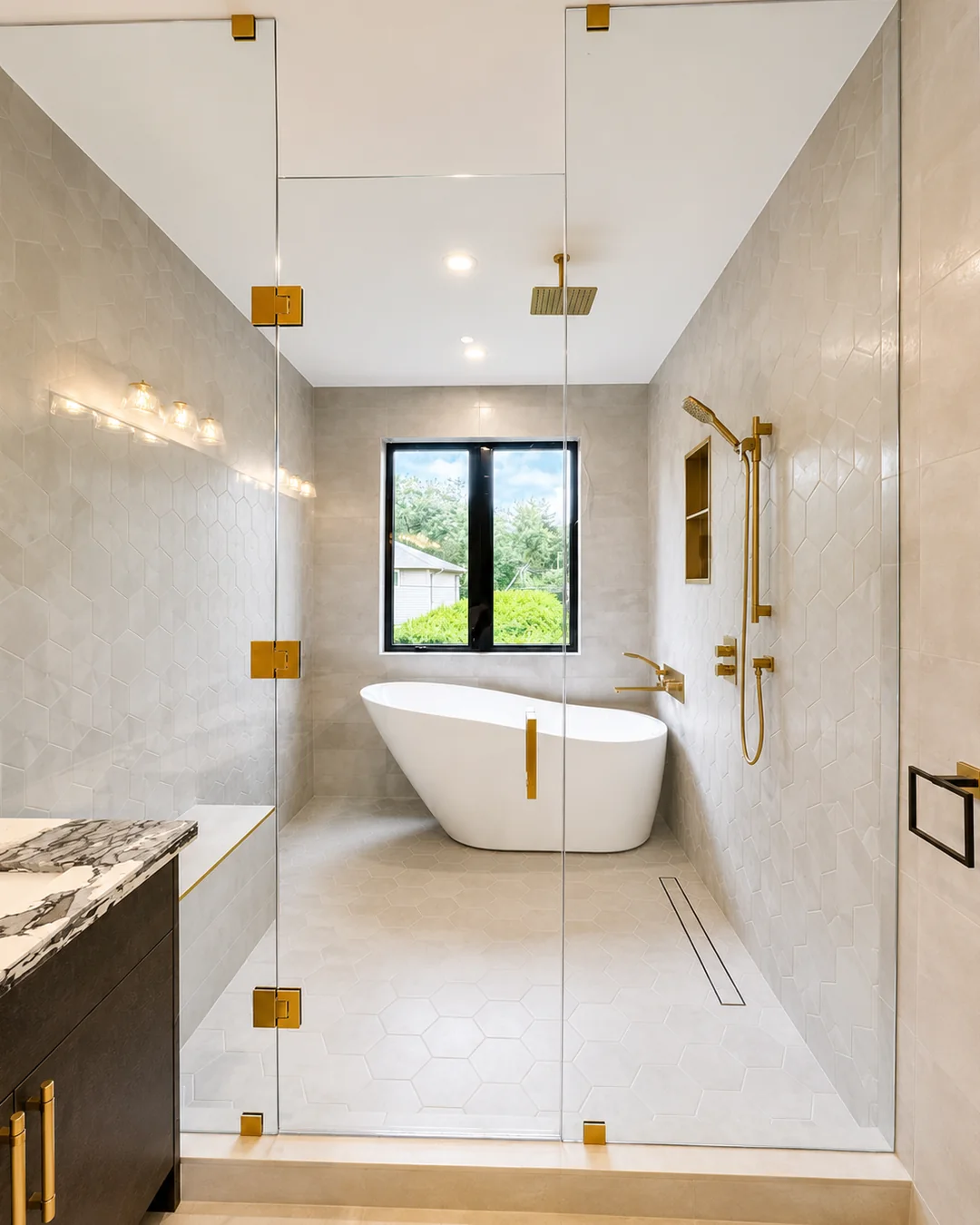 Spa bathroom with freshly painted walls, a glass shower, freestanding tub and gold fixtures