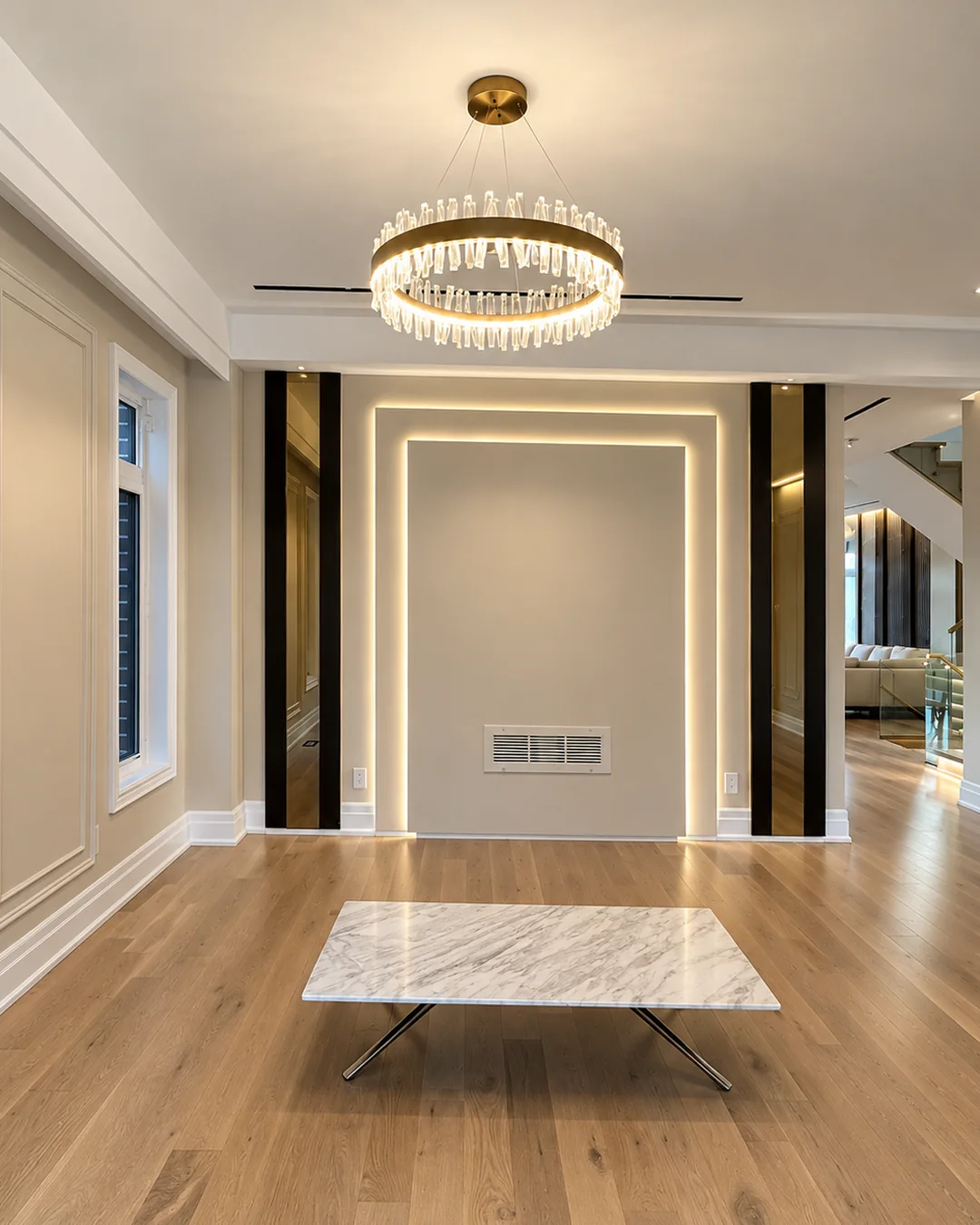 Living room with painted panel moulding, an LED-lit feature wall and a crystal chandelier